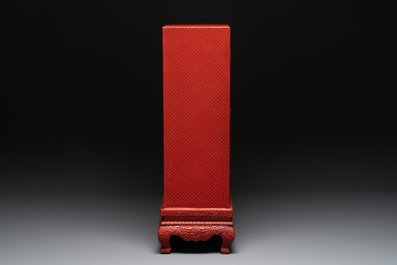 A Chinese cinnabar lacquer 'mountainous landscape' cabinet on a stand, 19th C.