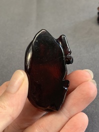 A pair of Chinese cherry amber or faturan recumbent oxen on wooden stands, Republic