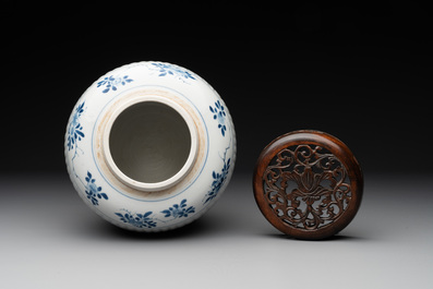 A Chinese blue and white jar with floral design and a wooden cover, Kangxi