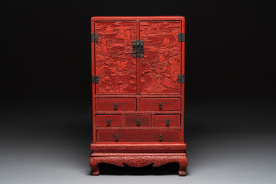 A Chinese cinnabar lacquer 'mountainous landscape' cabinet on a stand, 19th C.