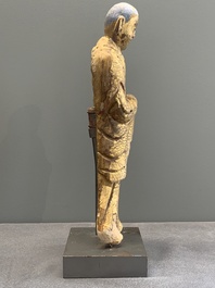A Chinese gilt and polychromed stucco figure of a monk, Ming