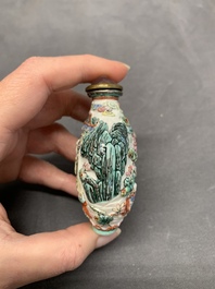 A Chinese famille rose relief-molded snuff bottle with an animated river landscape, Jiaqing mark and of the period