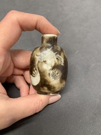 A Chinese famille rose molded 'Buddhist lions' and a grisaille 'dragon' snuff bottle, Qianlong and Daoguang mark, 19th C.