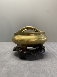 A Chinese bronze tripod censer on a wooden stand, Song Zhu Xuan 松竹軒 mark, 18th C.