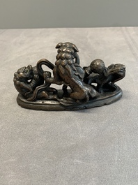 A rare Chinese bronze 'three dancing lions' paperweight or brush rest, Ming