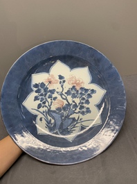 A Chinese blue, white and copper-red powder blue-ground 'peony' dish, Kangxi