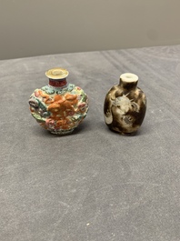 A Chinese famille rose molded 'Buddhist lions' and a grisaille 'dragon' snuff bottle, Qianlong and Daoguang mark, 19th C.