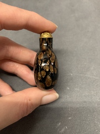 A Chinese aventurine-splashed black glass snuff bottle with a gilt stopper, 18/19th C.