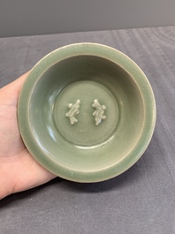 A Chinese Longquan celadon 'twin fish' dish and two 'twin fish' saucers, Yuan/Ming
