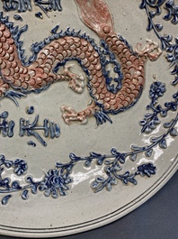 A Vietnamese or Annamese relief-molded blue, white and orange 'dragon' dish, 19th C.