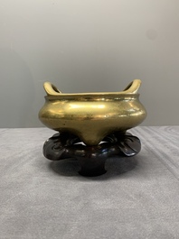 A Chinese bronze tripod censer on a wooden stand, Song Zhu Xuan 松竹軒 mark, 18th C.