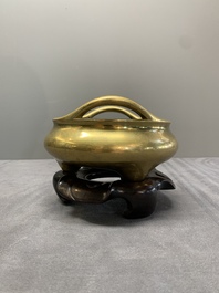 A Chinese bronze tripod censer on a wooden stand, Song Zhu Xuan 松竹軒 mark, 18th C.