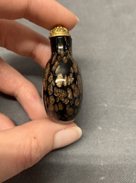 A Chinese aventurine-splashed black glass snuff bottle with a gilt stopper, 18/19th C.