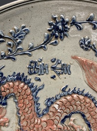 A Vietnamese or Annamese relief-molded blue, white and orange 'dragon' dish, 19th C.