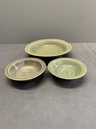 A Chinese Longquan celadon 'twin fish' dish and two 'twin fish' saucers, Yuan/Ming