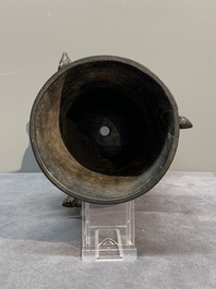 A Chinese archaistic bronze 'gu' vase and a 'hu' vase with rams in relief on a wooden stand, 18/19th C.