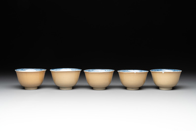 Five Chinese caf&eacute;-au-lait-ground blue and white cups and four saucers, conical shell mark, Kangxi