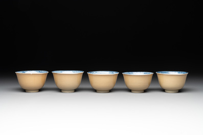 Five Chinese caf&eacute;-au-lait-ground blue and white cups and four saucers, conical shell mark, Kangxi