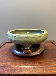 A Chinese Longquan celadon tripod censer on wooden stand, Yuan/Ming