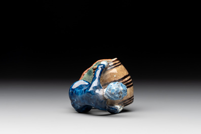 A polychrome Dutch Delft model of a boy rolling a 'wijn azijn' barrel, 18th C.