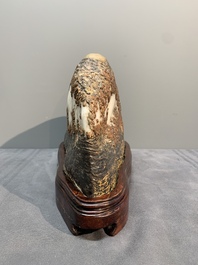 A Chinese wucai Lingbi stone scholar's rock on wooden stand, 20th C.