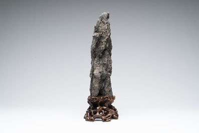A Chinese ying stone scholar's rock on wooden stand, 20th C.