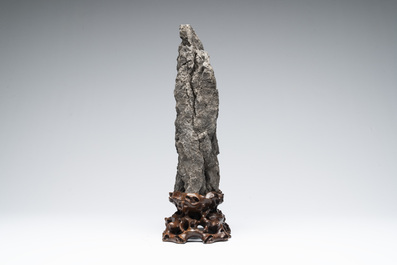 A Chinese ying stone scholar's rock on wooden stand, 20th C.