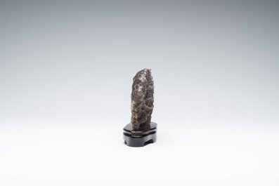 A Chinese grape agate scholar's rock on wooden stand, 20th C.