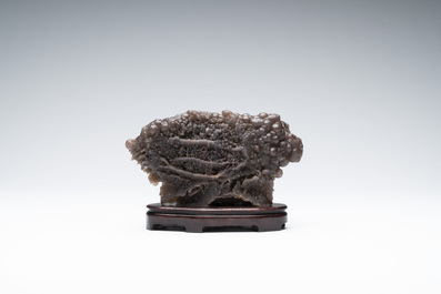 A Chinese grape agate scholar's rock on wooden stand, 20th C.