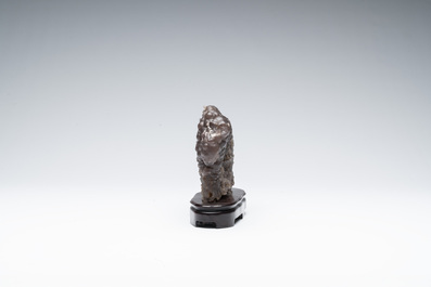 A Chinese grape agate scholar's rock on wooden stand, 20th C.