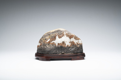 A Chinese wucai Lingbi stone scholar's rock on wooden stand, 20th C.