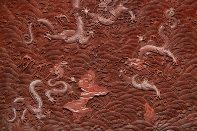 A rectangular Chinese carved red lacquer 'dragon' table screen, later wooden stand, Qianlong