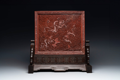 A rectangular Chinese carved red lacquer 'dragon' table screen, later wooden stand, Qianlong