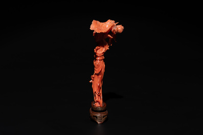 A Chinese red coral figure of a standing lady holding a flower, 19/20th C.