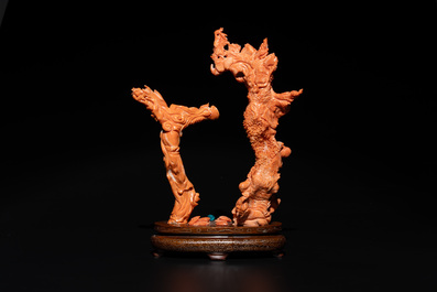 A Chinese pink-orange coral group of a goddess of spring, a wise man and children in a pine tree, 19/20th C.