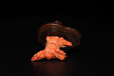 A Chinese red coral figure of a laughing Buddha on wooden stand, 19/20th C.