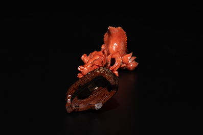 A Chinese red coral figure of a standing lady holding a flower, 19/20th C.