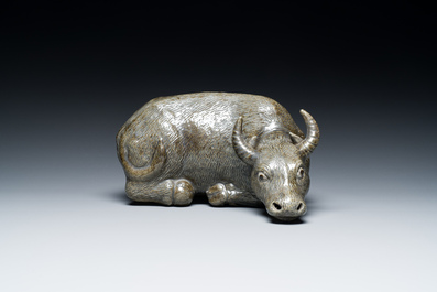 A Chinese brown-grey-glazed recumbent water buffalo on wooden stand, 19th C.