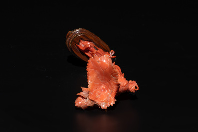 A Chinese red coral figure of a standing lady holding a flower, 19/20th C.