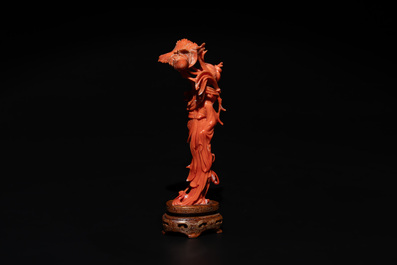 A Chinese red coral figure of a standing lady holding a flower, 19/20th C.