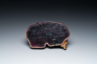 A Chinese brown-grey-glazed recumbent water buffalo on wooden stand, 19th C.