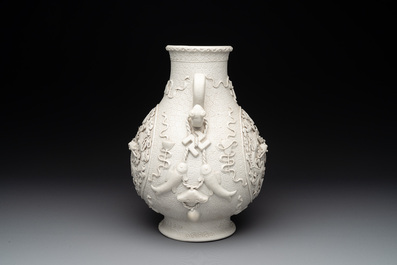 A Chinese white-glazed biscuit 'hu' vase with dragons, Qianlong mark, 19/20th C.