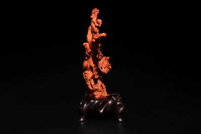 A Chinese red coral group of goddesses on wooden stand, 19/20th C.