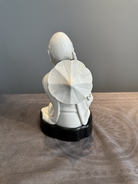 A Chinese Dehua blanc de Chine Luohan on wooden stand, 19/20th C.