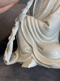 A Chinese Dehua blanc de Chine Luohan on wooden stand, 19/20th C.