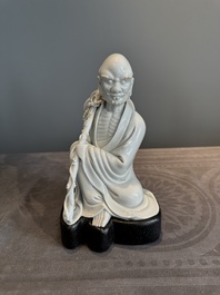 A Chinese Dehua blanc de Chine Luohan on wooden stand, 19/20th C.