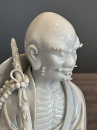 A Chinese Dehua blanc de Chine Luohan on wooden stand, 19/20th C.