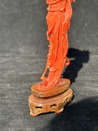 A Chinese red coral figure of a standing lady holding a flower, 19/20th C.