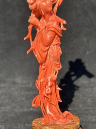 A Chinese red coral figure of a standing lady holding a flower, 19/20th C.