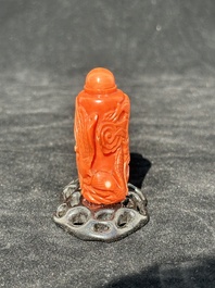 A Chinese carved red coral 'dragon' snuff bottle on wooden stand, 19/20th C.